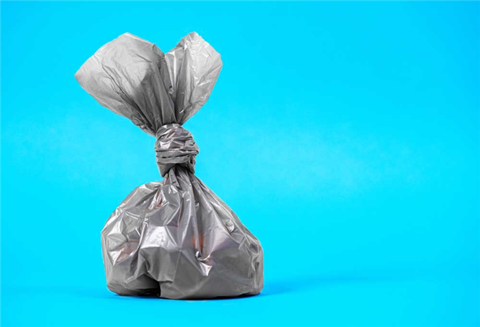 Small tied plastic bag on a bright blue background.